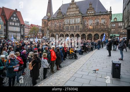 Bremen, Deutschland. November 2023. Teilnehmer einer Gedenkfeier für die Opfer des Terroranschlags der Hamas auf Süd-Israel stehen auf dem Bremer Marktplatz. Hunderte von Menschen waren gekommen, um vor dem Bremer Parlament zu gedenken. Quelle: Focke Strangmann/dpa/Alamy Live News Stockfoto