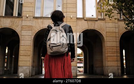 Attraktive Frau Geht Mit Rucksack In Die Stadt Und Schaut Sich Um Stockfoto