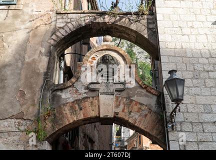 Mittelalterlicher Bogen. Tor zum Eingang zur Festung Kotor, Montenegro. Lateinische Inschrift: „Regia minutiae Rupees via“ Stockfoto