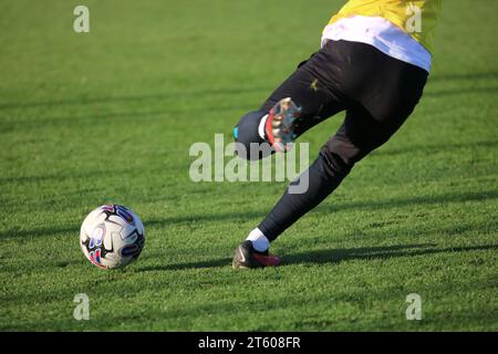 Spieler, der EFL Puma Ball auf dem Grass Fußballplatz tritt Stockfoto