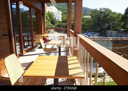 Tische und Stühle auf dem Balkon im Restaurant mit Bergblick. Das Konzept des Reisens. Malerische Aussicht Stockfoto