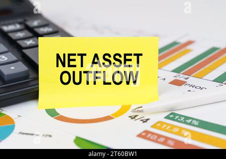 Geschäftskonzept. In Geschäftsberichten gibt es einen Rechner und ein Schild mit der Aufschrift "Netto Asset Outflow" Stockfoto