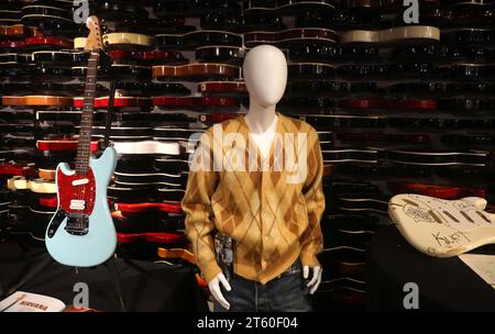 New York, New York, USA. November 2023. Nirvana Kurt Cobain auf der Bühne gespielte 'Skystang I' 1993 Fender MG - Mustang E-Gitarre aus der Sammlung von Kurts Bruder Chad Cobain mit einer Schätzung von 1 Million - 2 Millionen Dollar, Nirvana Kurt Cobain besaß und getragene Argyle Cardigan im Besitz von Kurt Cobains Mitbewohnerin im Exodus Recovery Center Ende März 1994, mit einem Schätzwert von 6.000 - 8.000 Dollar und Nirvana Kurt Cobain auf der Bühne spielte und zerschmetterte Band-signierte Fender Stratocaster Electric Guitar mit einem Schätzwert von 500.000 - 700.000 Dollar, die in der Pressevorschau für Julians Auktionen gespielt wurden, Stockfoto