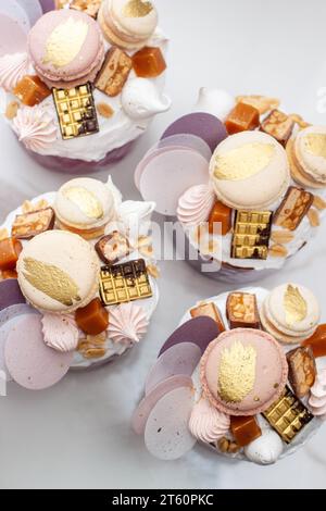 Orthodoxes osterbrot reich dekoriert mit Süßigkeiten, Makronen, Schokolade und essbaren Blüten mit gesalzener Karamellfüllung Stockfoto