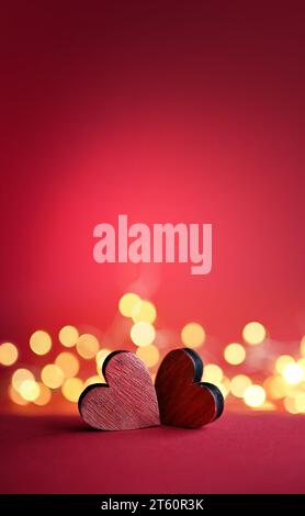 Zwei rote Valentinsholz-Herzen auf rotem Hintergrund. Stockfoto