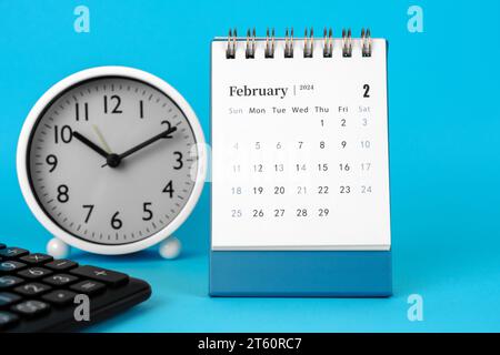 Februar 2024 Schreibtischkalender auf blauem Hintergrund Stockfoto