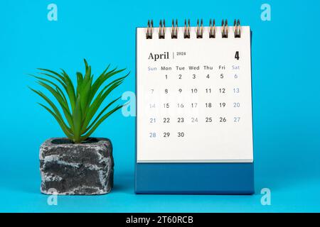 April 2024 Schreibtischkalender auf blauem Hintergrund Stockfoto