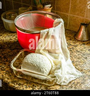 Weichkäse im Glasbehälter, nachdem er mit Käse geschlossen aus Molke gesaugt wurde Stockfoto