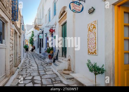 Enge Gasse mit weiß getünchten traditionellen Häusern und Geschäften in Pyrgos, dem größten und charmantesten Dorf im bergigen Tinos, Kykladen, Griechenland. Stockfoto