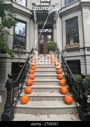 Kürbisse säumen zu Halloween die Treppe eines Stadthauses im Park Slope Viertel von Brooklyn; New York. Stockfoto