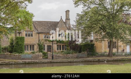 Honigfarbene malerische und alte Cotswolds-Cottages am Fluss Windrush Stockfoto