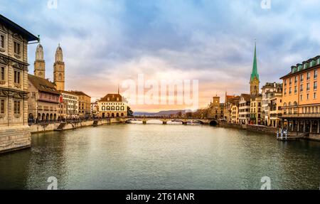 Panoramablick auf das Stadtzentrum von Zürich, Schweiz. Die Altstadt von Zuerich mit dem berühmten Fraumunster und der Grossmunster-Kirche am Ufer der Limmat bei Sonnenuntergang Stockfoto