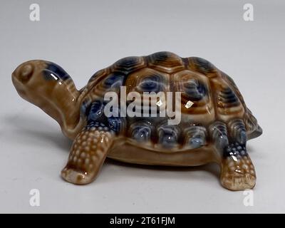 Eine Nahaufnahme einer grünen Keramikschildkrötenfigur auf weißem Hintergrund Stockfoto