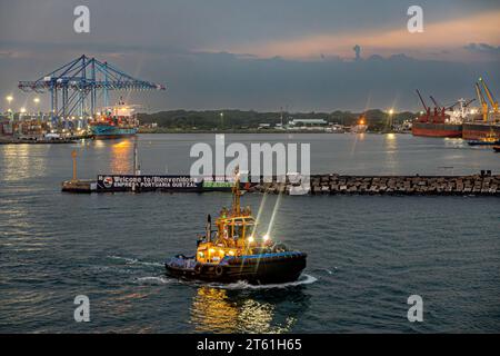 Guatemala, Puerto Quetzal - 20. Juli 2023: Abendliche Wolkenlandschaft. Saam Itza Schlepper direkt vor dem Hafen. Container-Terminal links und Bulk-Terminal ein Stockfoto