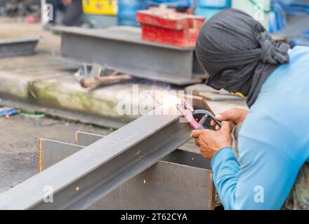 Arbeiter Schweißer ohne persönliche Schutzausrüstung Schweißsockelträger auf der Baustelle. Stockfoto