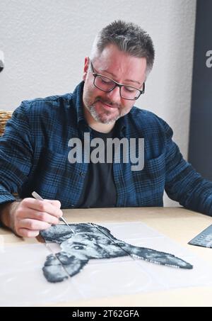 Pforzheim, Deutschland. November 2023. Oliver Lemke kreiert ein Hundeporträt aus aufbügelbaren Perlen in seiner Wohnung. Quelle: Uli Deck/dpa/Alamy Live News Stockfoto