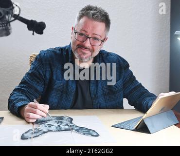 Pforzheim, Deutschland. November 2023. Oliver Lemke kreiert ein Hundeporträt aus aufbügelbaren Perlen in seiner Wohnung. Quelle: Uli Deck/dpa/Alamy Live News Stockfoto