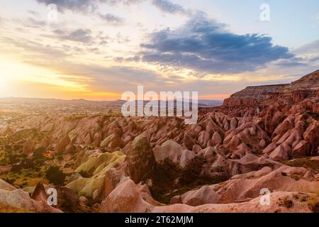 Der Sonnenuntergang in Kappadokien, in strahlenden Farben getaucht, fängt die letzten Strahlen des Tages ein und wirft einen strahlenden Glanz über die einzigartige Landschaft darunter, insbesondere die Stockfoto