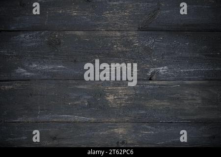 Verwitterter Holztisch. Dunkelgraue Holzbretttextur, abstrakter Grunge-Hintergrund. Alter Holzboden, gemalte rustikale Holzwand. Schwarze Vintage-Leisten, n Stockfoto