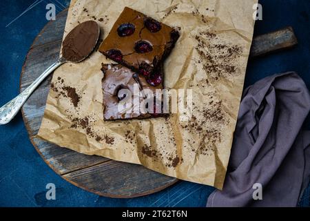Leckerer Kirschbrownie, Brownies in Papier auf hölzernem Hintergrund, Blick von oben. Stockfoto