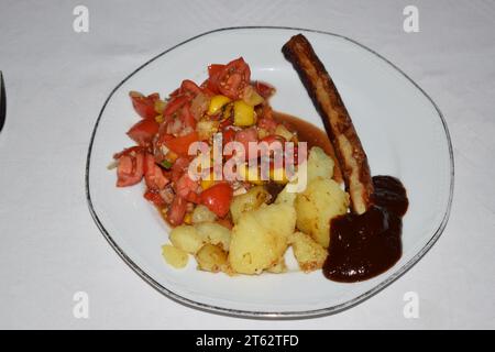 Farbenfroher Tomatensalat mit Wurst und Kartoffeln Stockfoto