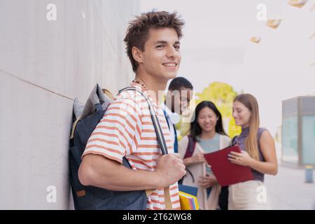 Glücklicher Student auf dem Campus, der draußen in die Kamera lächelt. Stockfoto