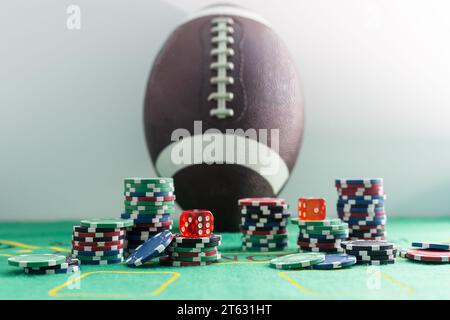 Studio Shot Komposition aus Poker Chips, Würfeln, Spielkarten, Fußball und Dollars auf dem Schreibtisch mit Grunge-Textur auf schwarzem Hintergrund. Casino Stockfoto