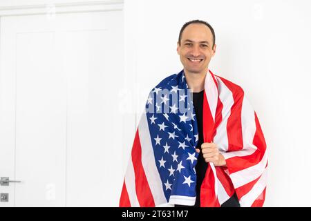 Gutaussehender Mann mit US-Flagge auf hellem Hintergrund. Gedenkfeier Stockfoto