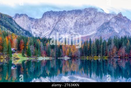 Wunderschöner Blick auf den berühmten Superior Fusine See mit Mount Mangart im Hintergrund bei Sonnenaufgang, Tarvisio, Italien. Stockfoto