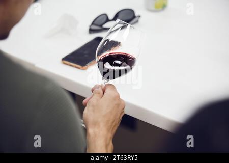 Porträt von der Rückseite eines professionellen Sommeliers, der Rotwein und Analysefarbe aussieht, Nahaufnahme. Stockfoto