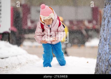 Harbin, Chinas Provinz Heilongjiang. November 2023. Ein Mädchen spielt mit Schnee in Harbin, nordöstlich Chinas Provinz Heilongjiang, 8. November 2023. Quelle: Wang Jianwei/Xinhua/Alamy Live News Stockfoto