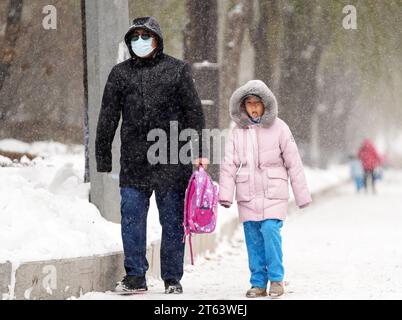 Harbin, Chinas Provinz Heilongjiang. November 2023. Ein Mädchen versucht, Schnee mit der Zunge in Harbin, nordöstlich Chinas Provinz Heilongjiang, am 8. November 2023 zu probieren. Quelle: Wang Jianwei/Xinhua/Alamy Live News Stockfoto