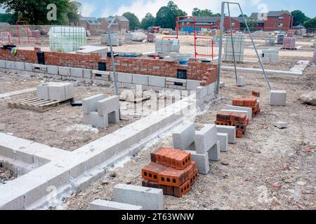 Betonblöcke werden an die Baustelle geliefert und neben dem Arbeitsplatz platziert und sind bereit für Mauerwerk Stockfoto