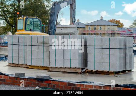 Betonblöcke werden an die Baustelle geliefert und neben dem Arbeitsplatz platziert und sind bereit für Mauerwerk Stockfoto