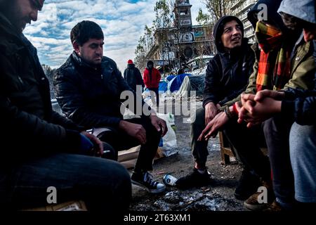 Michael Bunel/Le Pictorium - Exil im Land der Menschenrechte - 09/02/2018 - Frankreich/Ile-de-France (Region)/Paris - Eine Gruppe von Flüchtlingen, die sich durch ein improvisiertes Feuer erwärmen. Flüchtlinge guineischer, eritreischer, pakistanischer und afghanischer Herkunft gruppieren sich häufig nach Gemeinschaften innerhalb der Lager. Februar 2018. Paris, Frankreich. Im Oktober 2015 legte die Gemeinde achtzehn Verpflichtungen in einem Dokument mit dem Titel "Mobilisierung der Pariser Gemeinschaft zur Aufnahme von Flüchtlingen" vor. Das Dokument beginnt mit diesem Satz: "Paris wird sich, wie andere Flüchtlingsstädte, der Herausforderung stellen, viele aufzunehmen Stockfoto