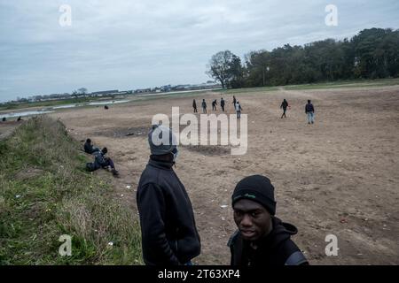 Michael Bunel/Le Pictorium - November 2016, Evakuierung des Calais'Dschungels - 11/11/2021 - Frankreich/Haut de France/Calais - sudanesische Flüchtlinge spielen im Moor Fußball, wo sie zwischen den Vertreibungen mehrere Zelte errichtet haben. Seither wurden Steine installiert, um den Zugang zum Moor zu verhindern. Verbände können das Gebiet nicht mehr nutzen, um Lebensmittel zu verteilen oder Wassertanks zu füllen. Im November 2016 wurde der „Dschungel“ von Calais, dem größten Sluttenviertel Europas, evakuiert. Fünf Jahre später sind die Exilanten auf der Straße nach Großbritannien noch dort und zwischen ihnen werden regelmäßig Lager angelegt Stockfoto