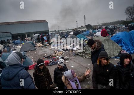 Michael Bunel/Le Pictorium - November 2016, Evakuierung des Calais'Dschungels - 16/11/2021 - France/Haut de France/Grande Synthe - Eine Familie plaudert um ein Feuer, während sie darauf wartet, dass das Lager von der Polizei evakuiert wird. Journalisten, die heute Morgen vor Ort waren, haben den Flüchtlingen mitgeteilt, dass das Lager abgebaut werden soll. Die Präfektur hatte versprochen, die Exilanten und Verbände 48 Stunden im Voraus zu informieren. November 2021. Grande Synthe. Im November 2016 wurde der „Dschungel“ von Calais, dem größten Sluttenviertel Europas, evakuiert. Fünf Jahre später machten sich die Exilanten auf den Weg nach Großbritannien Stockfoto