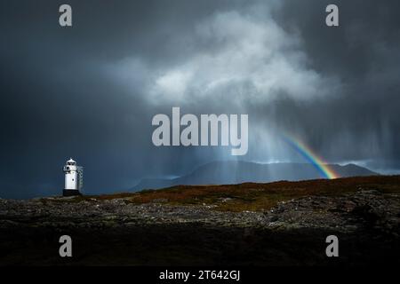 Eine Regenwolke, die hinter dem Rhue-Leuchtturm an der Westküste Schottlands vorbeizieht. Stockfoto