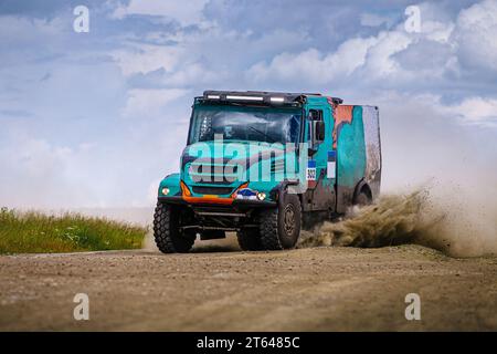 Rennwagen fährt auf staubiger Straße während der Cross Country-Rallye mit hoher Geschwindigkeit Stockfoto