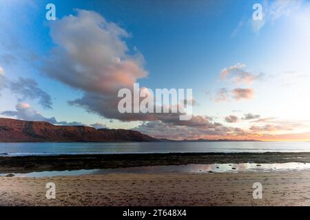 Spanien, Kanarische Inseln, La Graciosa: Sonnenuntergang auf Lanzarote, fotografiert vom Strand Francesca auf der Insel La Graciosa Stockfoto