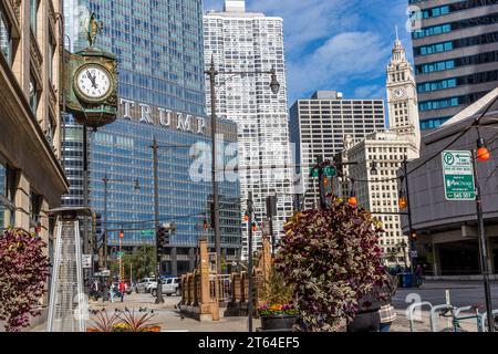 Die Uhr im Juweliergebäude wird kurz vor Hochmittags angezeigt. Im Hintergrund sehen Sie die Schrift Trump aus dem Trump Tower. Chicago, Usa Stockfoto