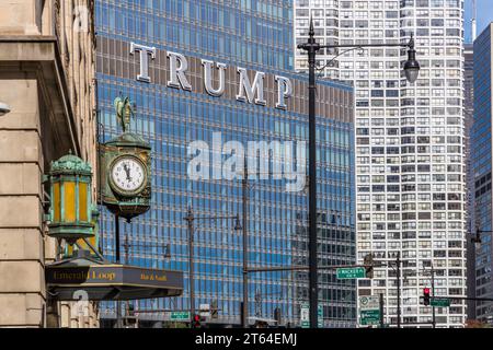 Die Uhr im Juweliergebäude wird kurz vor Hochmittags angezeigt. Im Hintergrund sehen Sie die Schrift Trump aus dem Trump Tower. Chicago, Usa Stockfoto