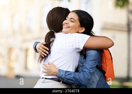 Porträt von zwei multirassischen jungen Frauen, die sich auf der Straße umarmen Stockfoto