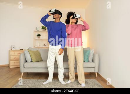 Das afroamerikanische Paar genießt zu Hause innovative VR-Gaming-Session Stockfoto