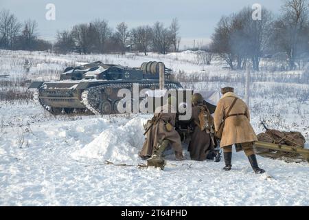 KRASNOE SELO, RUSSLAND - 5. FEBRUAR 2023: Fragment eines Duells zwischen sowjetischen Artilleristen und einer deutschen Selbstfahrwaffe. Militärisch-historisch Stockfoto