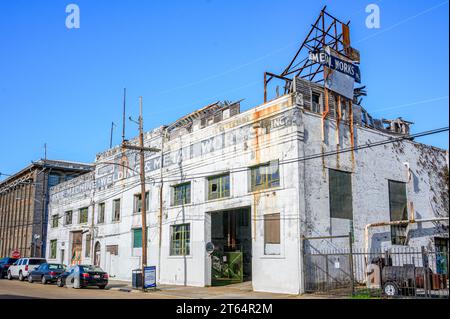 NEW ORLEANS, LA, USA - 22. AUGUST 2023: Vollständiger Blick auf das alte und ausgetretene Gebäude von Dixie Machine, Welding and Metal Works im Warehouse District Stockfoto