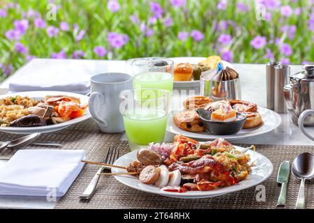 Einladende Anordnung am Frühstückstisch im Garten Stockfoto