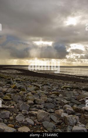 Eine felsige Küste bei Ebbe an einem bewölkten Tag in Cumbria. Stockfoto