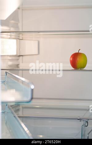 Fast leerer Kühlschrank mit nur einem Apfel, Diät, Gewichtsverlust Stockfoto