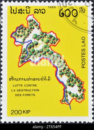 Gestempelte Briefmarke von Laos, die Karte mit den Wäldern von Laos, Waldschutz, um 1989 zeigt. Stockfoto